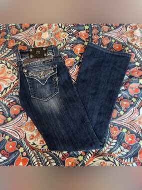 Dark wash Y2K Miss Me low rise bootcut jeans with distressed details